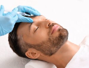 Nahaufnahme des Gesichts eines Mannes, dem Botox gespritzt wird