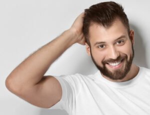 Porträt eines Herrn, der lacht und seine Hand in seinem Haar hält